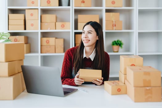 Asian female business owner handles delivery of orders to customers.