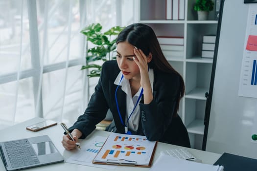 Portrait of business owner, woman using computer and financial statements Anxious expression on expanding the market to increase the ability to invest in business.