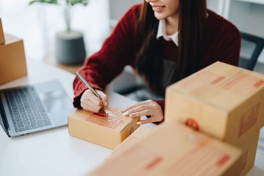 Asian female business owner handles delivery of orders to customers.