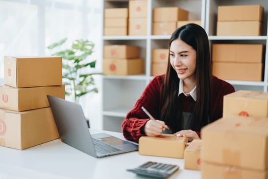 Asian female business owner handles delivery of orders to customers.