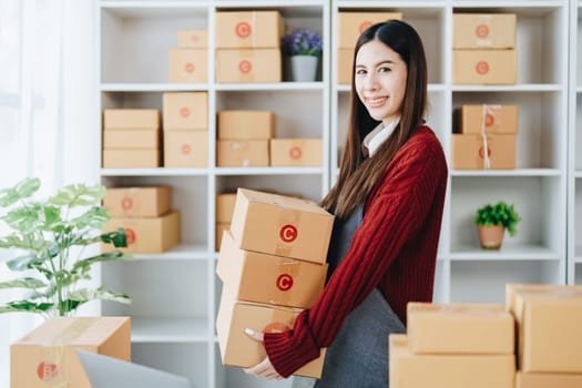 Asian female business owner handles delivery of orders to customers.