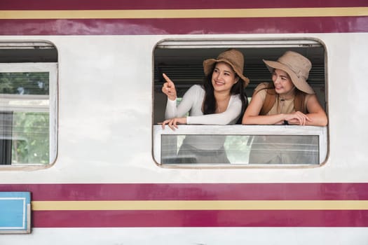 Two young female tourists are happy while waiting for their train at the train station to leave for their holiday..