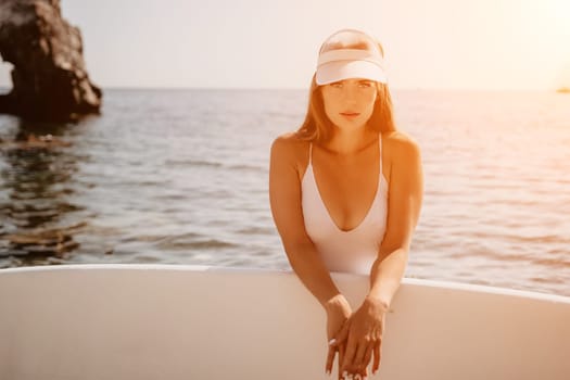 Close up shot of happy young caucasian woman looking at camera and smiling. Cute woman portrait in bikini posing on a volcanic rock high above the sea