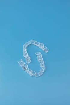Mouth guard. Transparent dental aligners for man's maxillary and mandibular teeth on blue background. Braces, Alignment of teeth. Orthodontic dentistry concept. Dental care. Copy Space. Vertical.