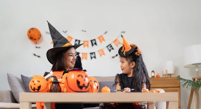 Happy family mother and child happy girl with Halloween at home together beautifully decorated.