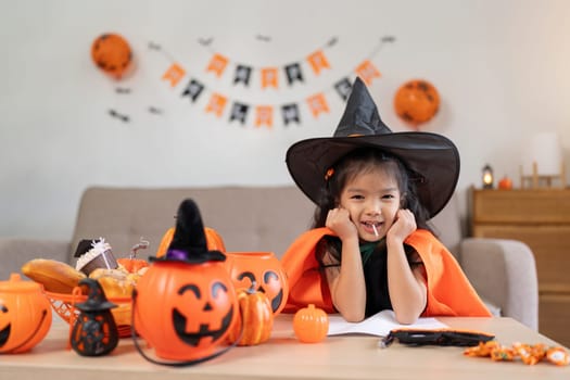 Halloween concept cute little child girl preparing to celebrate at home.