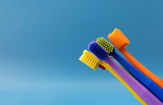 Design Bunch Of Colorful Toothbrushes on Blue Background. Oral Hygiene, Dental Care, Heathy Tooth And Smile. Copy Space For Text. Sustainable Mouth Product. Horizontal Plane. High quality photo