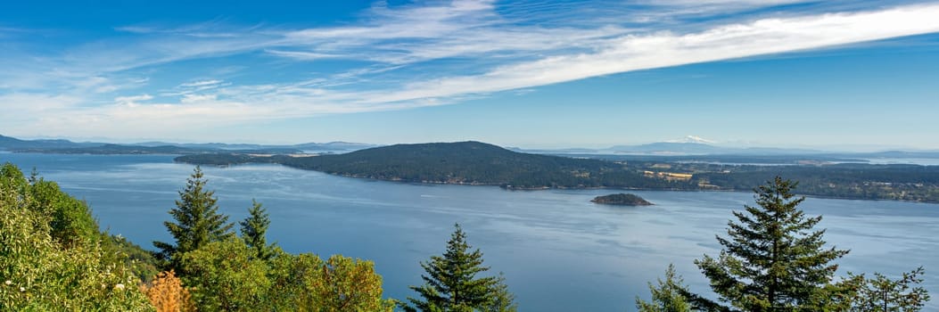Panoramic landscape view with Mountain Baker from Vancouver island. Overview of Pacific ocean bay on blue sky background.