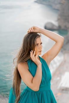 Woman sea green dress. Portrait of a happy woman with long hair in a long mint dress posing on a beach with calm sea bokeh lights on sunny day. Girl on the nature on blue sky background