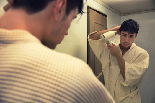 A man in a robe is brushing his hair