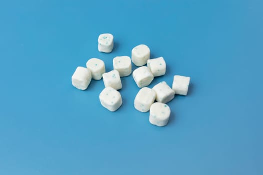 Bunch Of Healthy Sugar-Free Xylitol Cubes Of White Bubble Gum on Blue Background. Healthy Teeth, Beautiful Smile Concept. Top View, Copy Space. Heap of Chewing gum. Horizontal High quality photo