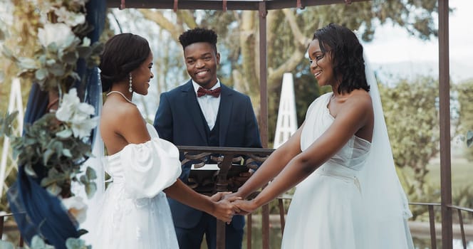 Women, lesbian wedding and celebration outdoor with priest for love, ceremony and together for commitment. Gay marriage, event and party with bride, black man and African lgbtq couple in garden.