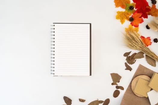 Workspace with blank copy space notebook mockup, blanket, envelopes, leaves on autumn background. Top view girl business, work concept top view seasonal autumn, cosy, cozy,.