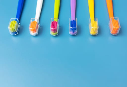Flat Lay Multicolored Toothbrushes on Blue Background On Top. Oral Hygiene, Dental Care, Heathy Tooth And Smile. Copy Space For Text. Sustainable Mouth Product. Horizontal Plane.