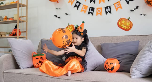 Cute little child girl with balloon. Happy family preparing for Halloween.