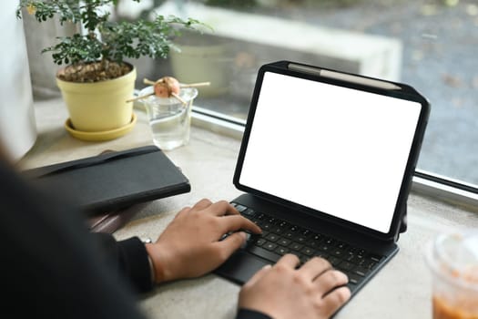 Close up image of businesswoman typing on keyboard of digital tablet.