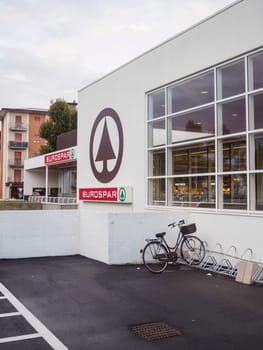 Cremona, Italy September 26th 2024 A bicycle is parked in front of a eurospar supermarket building with large windows