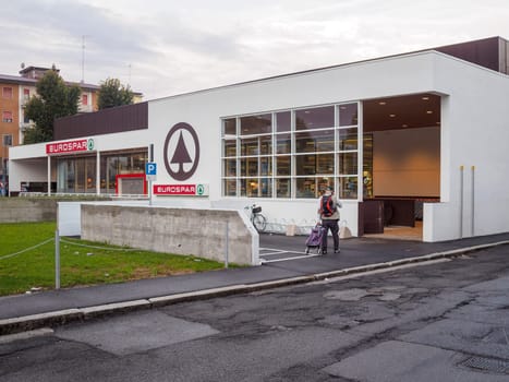 Cremona, Italy September 26th 2024 A man is walking away from a eurospar supermarket with a shopping cart after doing his grocery