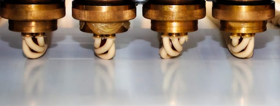 Complex equipment operates to extrude materials with precision, showcasing metal components and a streamlined process inside a busy manufacturing plant.