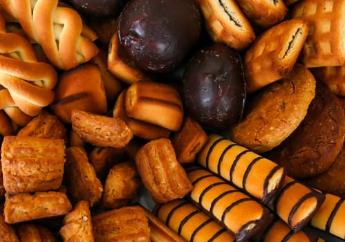 A colorful collection of delicious baked goods features cookies, biscuits, and pastries, showcasing diverse shapes and flavors that tempt any dessert lover.