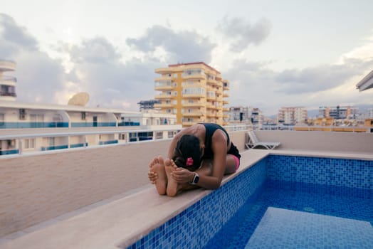 A person is relishing a serene moment spent by the pool located on a beautiful rooftop with a stunning backdrop