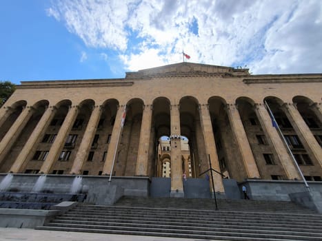 18 August 2024 Tbilisi Georgia modern building in the city center, gray stone stre fontaine, flag. High quality photo