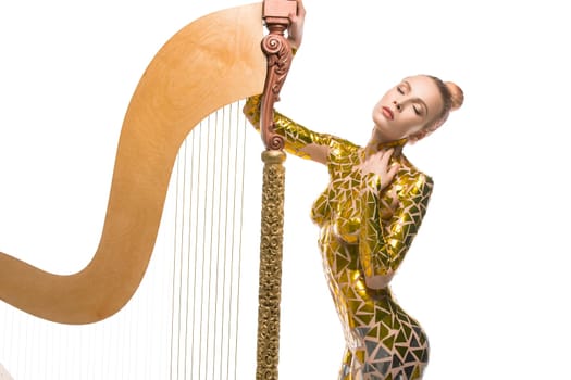 Sexy girl with gold tape body art cropped isolated view with a luxurious musical harp