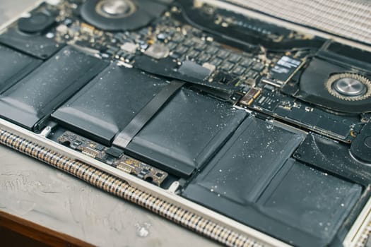 A detailed closeup view showcasing laptop battery components along with dustcovered circuitry elements
