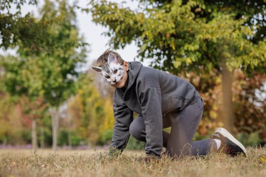 Teenage guy with cat mask and gloves doing Quadrobics. A Teenage guy in a cat mask Jumps like a cat, Quadrobics - Sport
