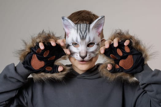 portrait quadrobics Teenager in cat mask on gray background , studio photo , imitating cat movements, Quadrobics - Sport