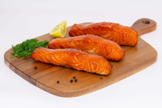 Enjoy grilled salmon fillets garnished with lemon zest and herbs, elegantly served on a rustic cutting board