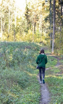 Woman walks on the forest trail.