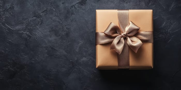 A beautifully wrapped gift box with a satin bow sits atop a dark textured surface, creating a minimalist aesthetic perfect for any celebratory event.