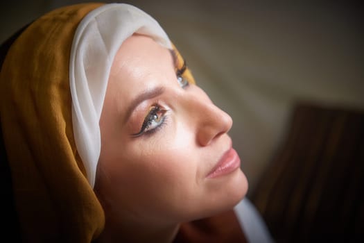 A girl dressed in stylized national clothes gazes thoughtfully, embodying Rebekah's character from the biblical narrative.