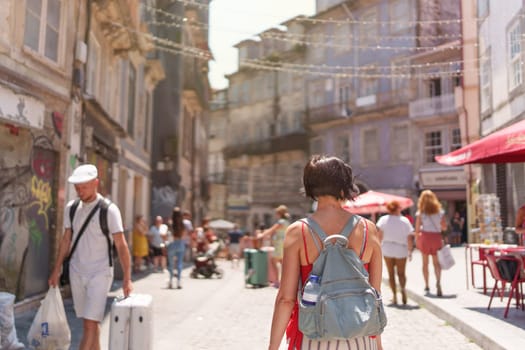 Female tourist walking through the city of Porto on a sunny summer day