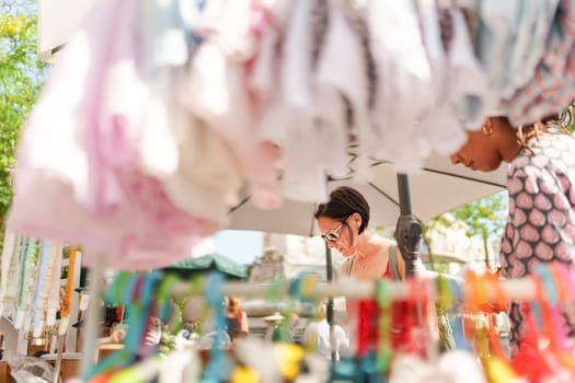 Women looking at clothes at a street market, Porto