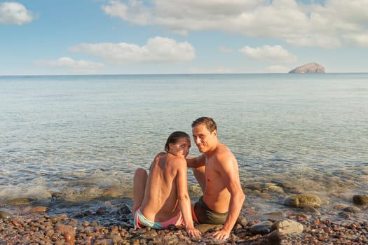 Couple in love smiling at camera on the seashore. Sardinia, Italy