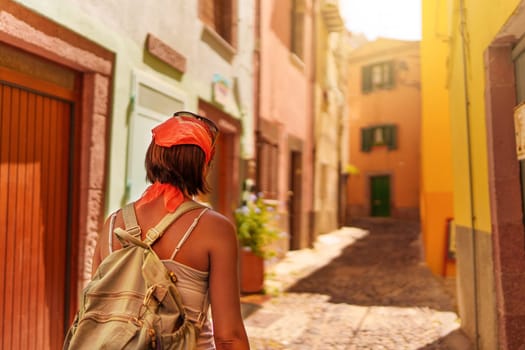 Female traveler walking through the streets of Bosa. Sardinia, Italy