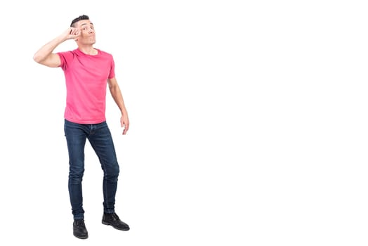 Full body of self assured young male model with dark hair in casual clothes touching forehead and looking at camera against white background