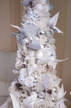 Decorated gold Christmas tree with golden patchwork ornament artificial star hearts presents for new year in white interior