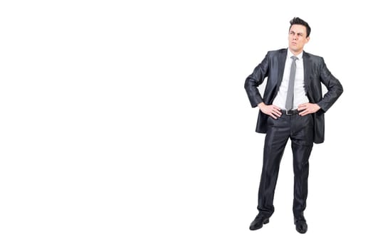 Full body of comic male entrepreneur in suit expressing doubt and looking up while standing with hands on waist against white background