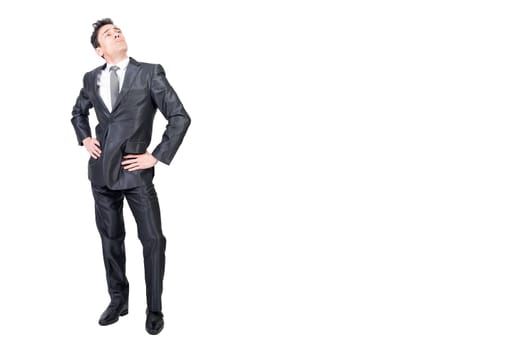 Full body of haughty male in formal outfit looking up with hands on waist isolated on white background in studio