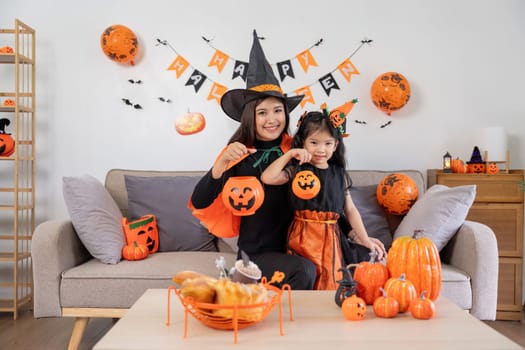 Happy family mother and child happy girl with Halloween at home together beautifully decorated.