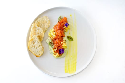 Salmon tartare with mint avocado cream mango and ciabatta croutons. High quality photo