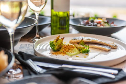 Dorado or sea bass fillet in cream sauce with broccoli on a white plate. High quality photo