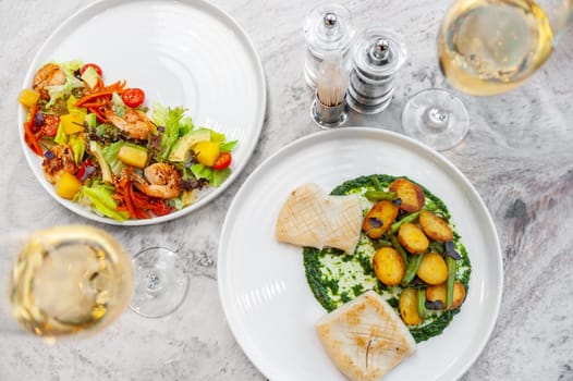 Fried squid with spinach sauce, baked potatoes and asparagus on a white plate. High quality photo