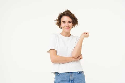 Portrait of woman standing in power pose, confident expression, cross arms on chest and smiles, stands over white background.