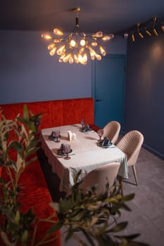 at a set table in a room with blue walls and a red sofa.