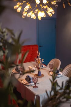 at a set table in a room with blue walls and a red sofa.