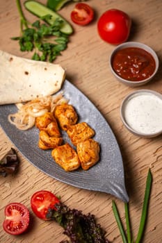 top view of a chicken kebab in a plate on a table in a restaurant.